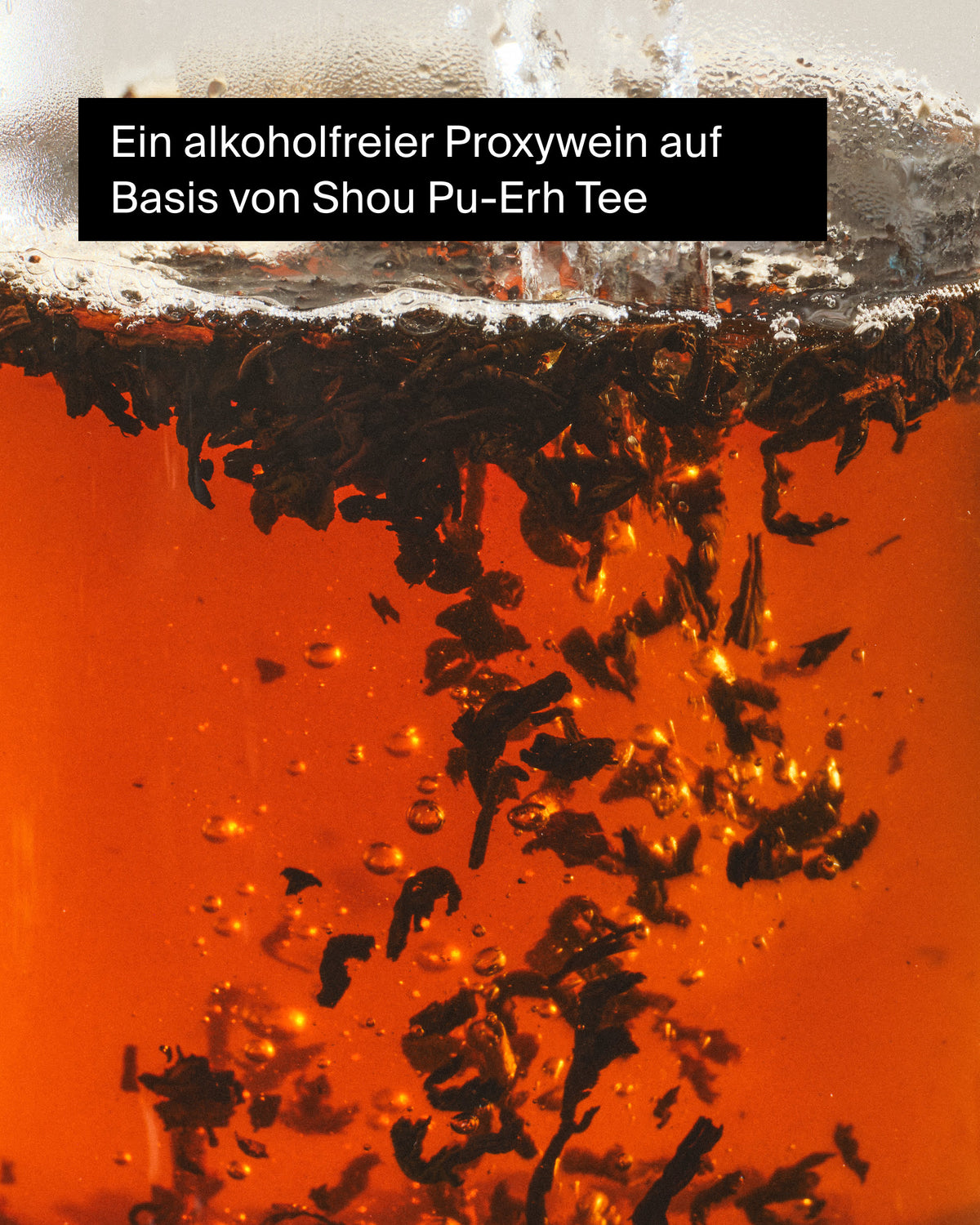 Nahaufnahme von bernsteinfarbener Shou Pu-Erh Tee-Flüssigkeit mit Bläschen, alkoholfreier Proxywein.