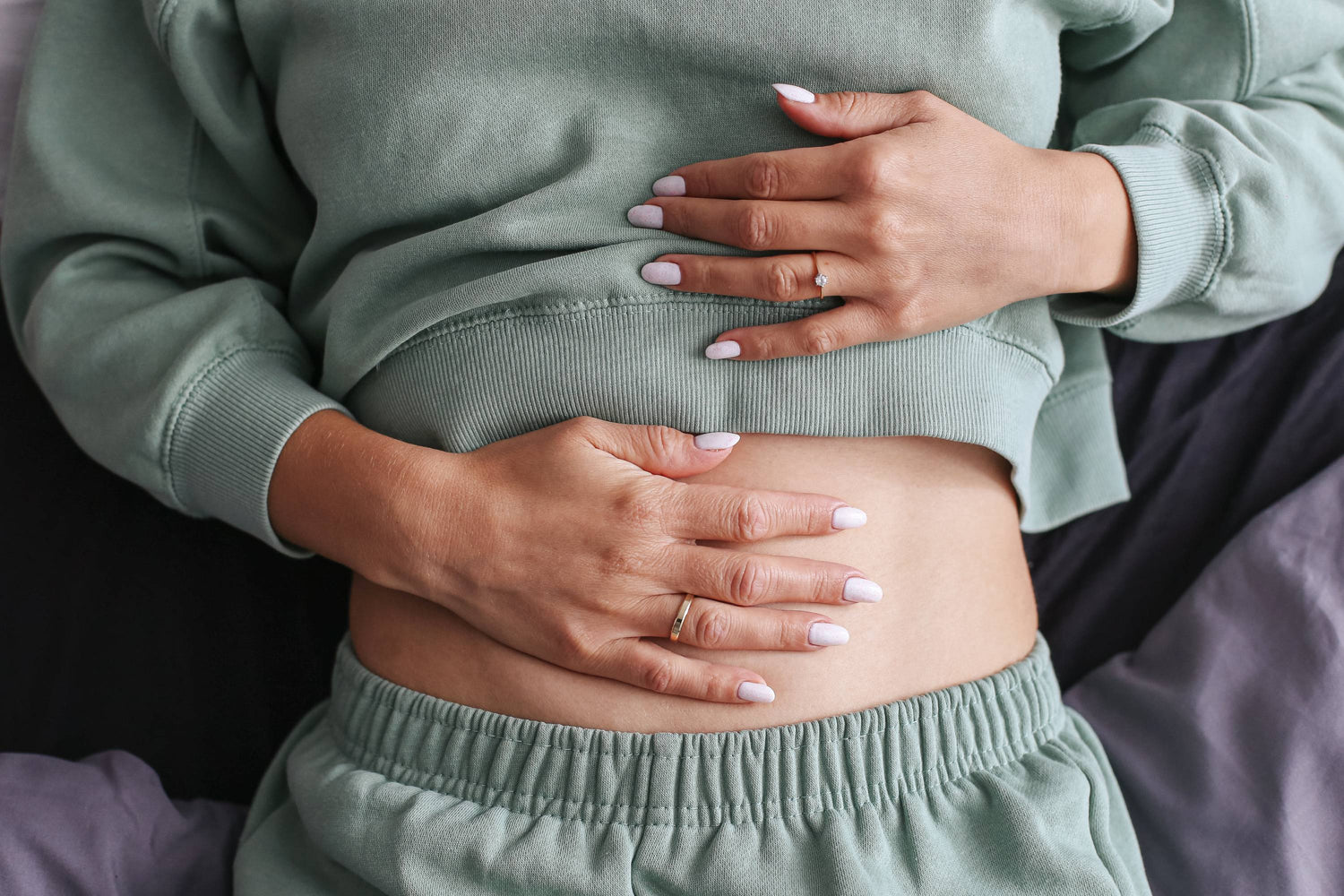 Frau hält ihren Bauch; Ballaststoffe regen die Darmbewegung an
