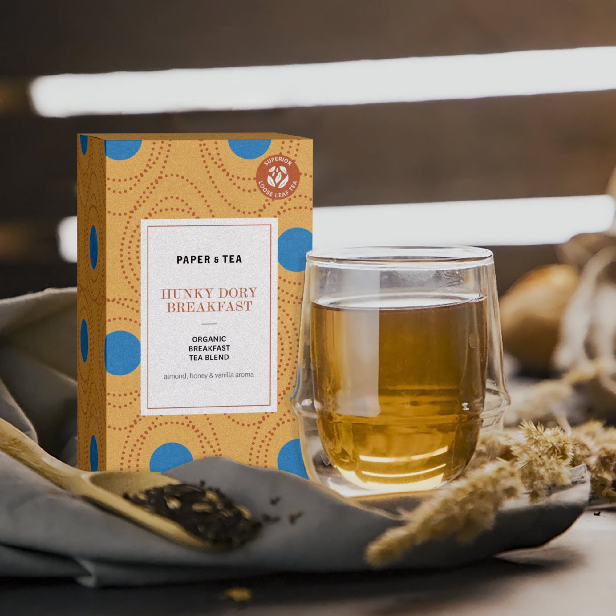 Tee-Box 'Hunky Dory Breakfast' von Paper & Tea mit Bio-Frühstückstee im Glas auf rustikalem Untergrund.